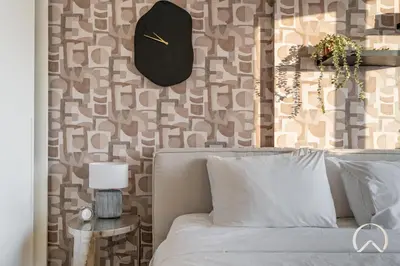 a bedroom with a bed and a clock on the wall at Oraya - Stylish 2BR in Socio Tower 2 With Pool View in Dubai