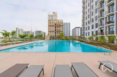a large swimming pool in the middle of a building at Oraya - Stylish 2BR in Socio Tower 2 With Pool View in Dubai