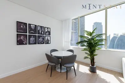 a dining room with a table and chairs and a plant at Sky Gardens, Park Avenue, DIFC - Mint Stay in Dubai