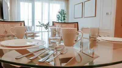 a glass table with glasses and silverware on it at Burj Royale Condo, Close to Dubai Mall & Attractions in Dubai