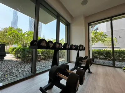 a gym with rows of dumbbells in a room with windows at Burj Royale Condo, Close to Dubai Mall & Attractions in Dubai