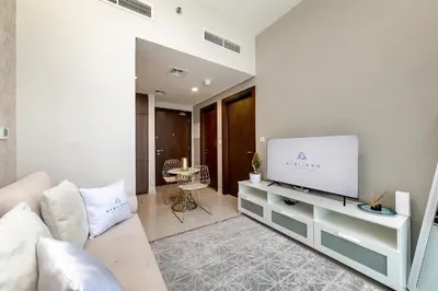 a living room with a couch and a flat screen tv at DAMAC Vera 1BR with Downtown & Burj Khalifa View in Dubai