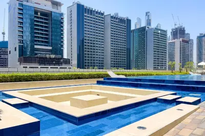 a pool in the middle of a city with tall buildings at DAMAC Vera 1BR with Downtown & Burj Khalifa View in Dubai