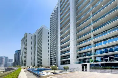 an image of a tall building with a pool at DAMAC Vera 1BR with Downtown & Burj Khalifa View in Dubai