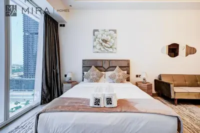 a bedroom with a large bed and a large window at Mira Holiday Homes - Fully Furnished Studio in JLT in Dubai