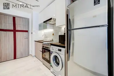 a kitchen with a refrigerator and a washing machine at Mira Holiday Homes - Fully Furnished Studio in JLT in Dubai