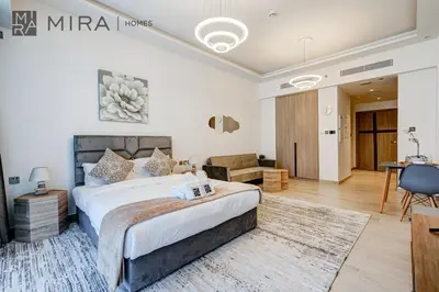 a bedroom with a bed and a living room at Mira Holiday Homes - Fully Furnished Studio in JLT in Dubai