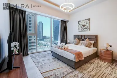 a bedroom with a large bed and a large window at Mira Holiday Homes - Fully Furnished Studio in JLT in Dubai