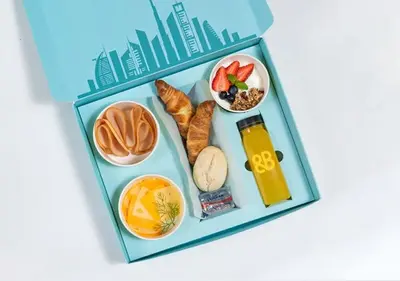 a bento box filled with food and drinks at Cosmos Living Charming Studio With Balcony in Dubai