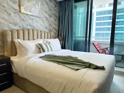 a bedroom with a large bed with a large window at Cosmos Living Charming Studio With Balcony in Dubai
