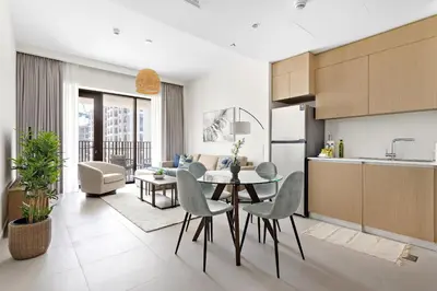 a kitchen and living room with a table and chairs at Silkhaus Chic 1BDR In Unique Neighborhood in Dubai