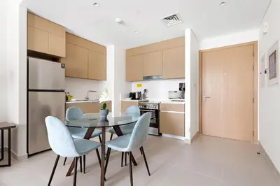a kitchen and dining room with a table and chairs at Silkhaus Chic 1BDR In Unique Neighborhood in Dubai