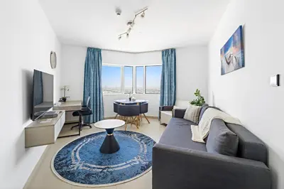 a living room with a couch and a table at 1BR Apartment minutes from Mall of the Emirates in Dubai
