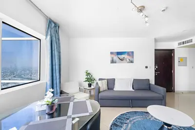 a living room with a couch and a large window at 1BR Apartment minutes from Mall of the Emirates in Dubai