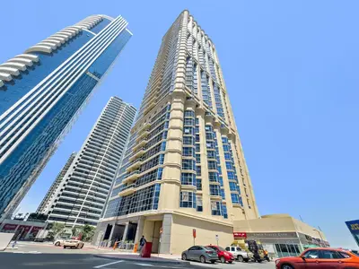 a tall building with cars parked in front of it at 1BR Apartment minutes from Mall of the Emirates in Dubai