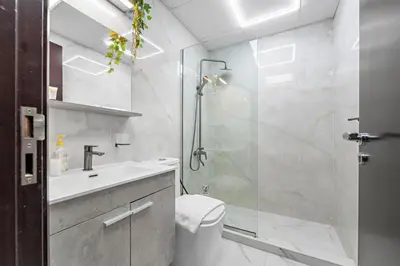 a bathroom with a shower and a toilet and a sink at 1BR Apartment minutes from Mall of the Emirates in Dubai