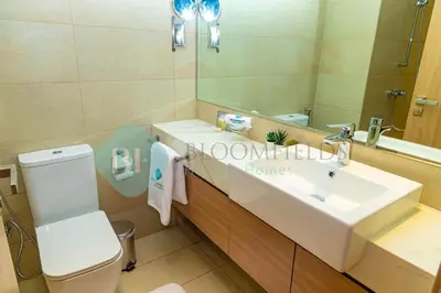 a bathroom with a sink and a toilet and a mirror at Bloomfields Stu View Azizi Riviera Meydan in Dubai