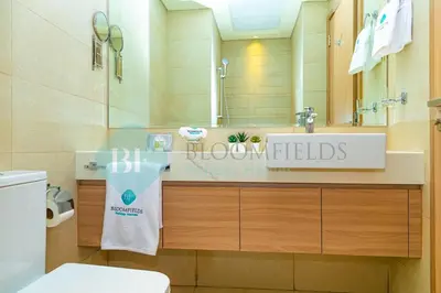 a bathroom with a sink and a toilet and a mirror at Bloomfields Stu View Azizi Riviera Meydan in Dubai