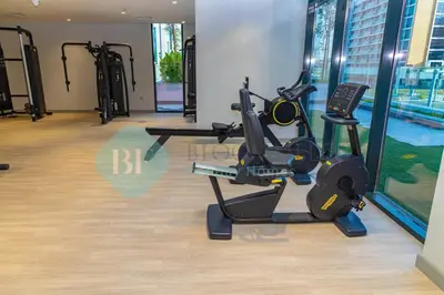 a gym with treadmills and ellipticals in a building at Bloomfields Stu View Azizi Riviera Meydan in Dubai
