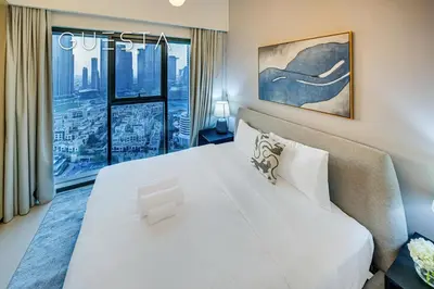 a bedroom with a large white bed and a window at Burj Royale - Burj Khalifa View, Downtown Dubai in Dubai