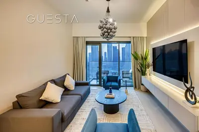 a living room with a couch and a tv at Burj Royale - Burj Khalifa View, Downtown Dubai in Dubai