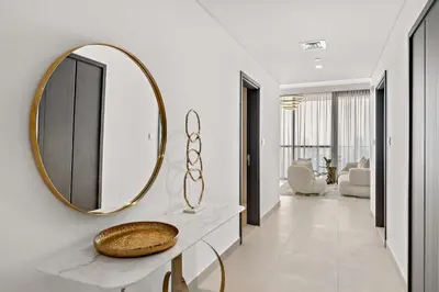 a bathroom with a mirror on a white wall at 3BR plus maid's room with Burj Khalifa views in Dubai