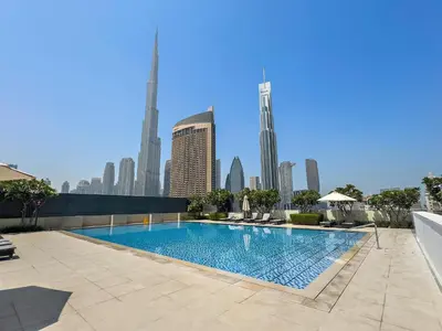 a swimming pool with a city skyline in the background at 3BR plus maid's room with Burj Khalifa views in Dubai