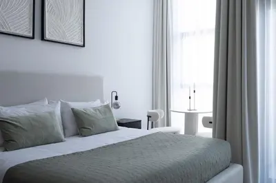 a bedroom with a white bed with a window at Waves - Comfort and Style in a 21st-Floor Studio With View in Dubai
