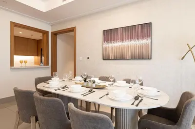 a dining room with a white table and chairs at SmartStay at Opera Grand - Stunning Burj Khalifa Views - Brand New Luxury Residences in Dubai