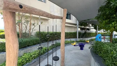 a playground in front of a building with swings at SmartStay at Opera Grand - Stunning Burj Khalifa Views - Brand New Luxury Residences in Dubai