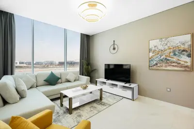 a living room with a couch and a tv at Your Keys Holiday Homes in Dubai