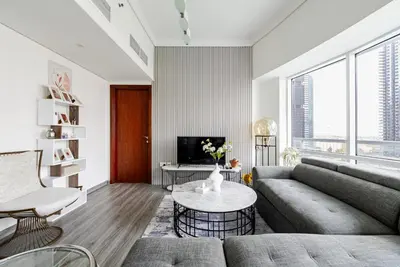 a living room with a couch and a table at Stunning skyline- lake view modern cozy apartment in Dubai