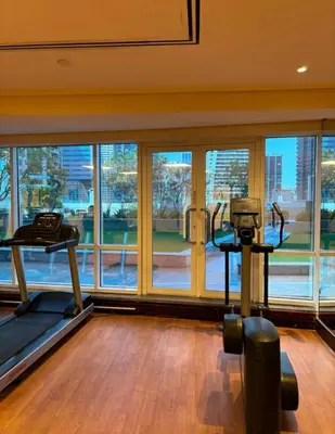 a gym with two treadmills and a large window at Stunning skyline- lake view modern cozy apartment in Dubai