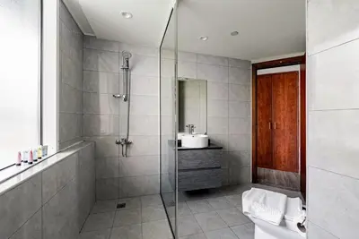 a bathroom with a shower and a toilet and a sink at Stunning skyline- lake view modern cozy apartment in Dubai