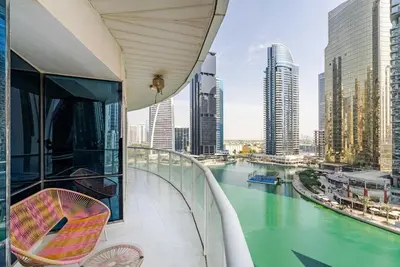 a balcony with a view of a river and buildings at Stunning skyline- lake view modern cozy apartment in Dubai