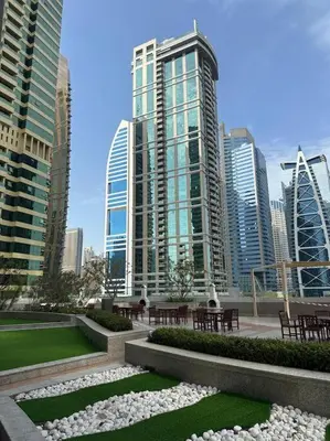 a park with tables and benches in a city at Stunning skyline- lake view modern cozy apartment in Dubai
