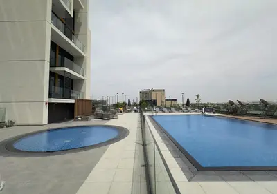 a large swimming pool next to a building at Extraordinary 2BR in Prive Residence, Dubai Hills in Dubai