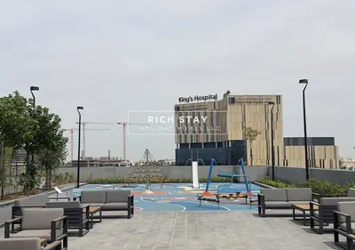 a playground with tables and chairs in front of a building at Extraordinary 2BR in Prive Residence, Dubai Hills in Dubai