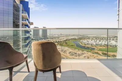 a balcony with two chairs and a view of a city at Tranquil Studio with Golf View in Dubai