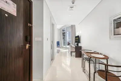 a hallway with a table and chairs in a room at Tranquil Studio with Golf View in Dubai