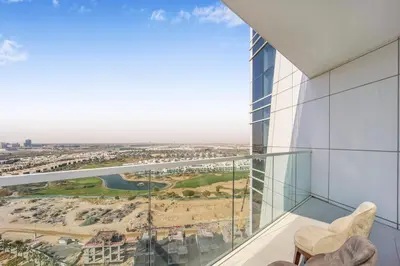 a glass balcony with a view of a city at Tranquil Studio with Golf View in Dubai