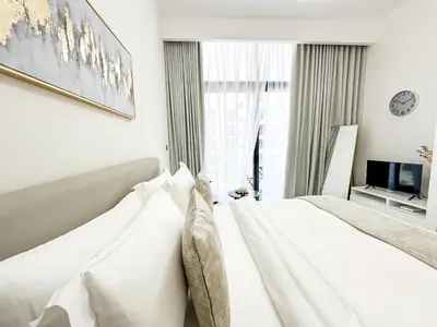 a white bedroom with a bed and a window at EasyGo - Unbeatable Deals on Urban Rentals in Riviera 16 in Dubai