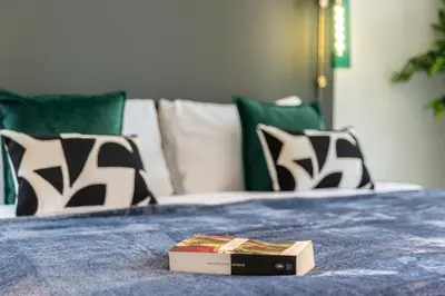 a book sitting on top of a bed with pillows at The Smart Concierge - Reehan 6 in Dubai