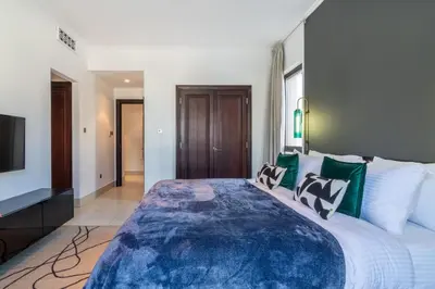 a large bedroom with a large bed and a television at The Smart Concierge - Reehan 6 in Dubai