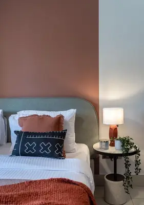 a bed with a blue headboard and a table with a lamp at The Smart Concierge - Reehan 6 in Dubai