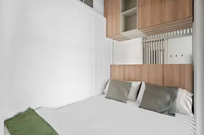 a bedroom with a white bed with green pillows at Bright Downtown Dubai Studio by Mall, Burj Khalifa & Fountains in Dubai