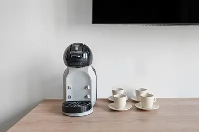 a coffee maker sitting on a table with three cups at New Design Studio next to Burj Khalifa, Mall & Dubai Fountain in Dubai