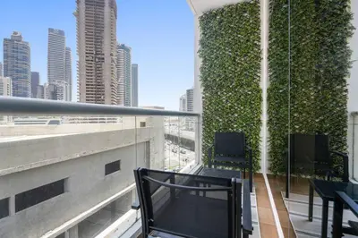a balcony with chairs and a green wall on a building at Renovated Studio next to Dubai Mall & Burj Khalifa in Dubai