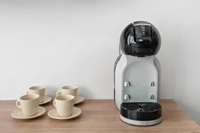a coffee maker sitting on a table with cups at Renovated Studio next to Dubai Mall & Burj Khalifa in Dubai