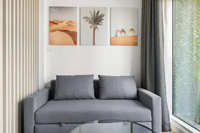 a living room with a couch and a glass table at Renovated Studio next to Dubai Mall & Burj Khalifa in Dubai